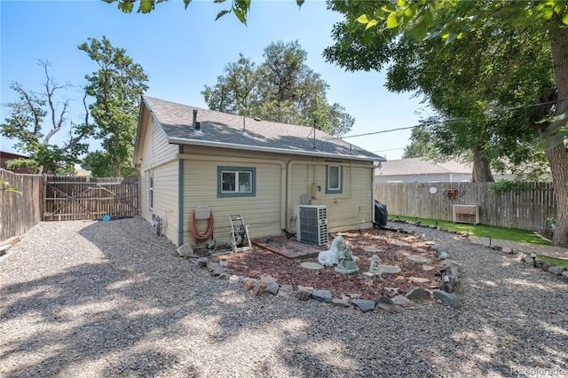 rear view of property featuring a fenced backyard and central air condition unit