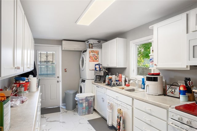 kitchen featuring marble finish floor, light countertops, stacked washing maching and dryer, white cabinetry, and a sink