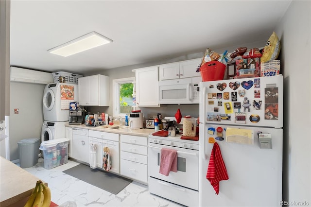 kitchen with white appliances, marble finish floor, light countertops, stacked washing maching and dryer, and a sink