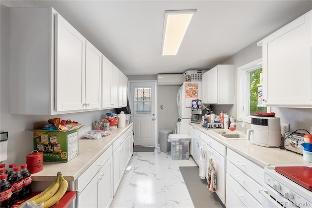 kitchen with white cabinets, marble finish floor, stove, and light countertops