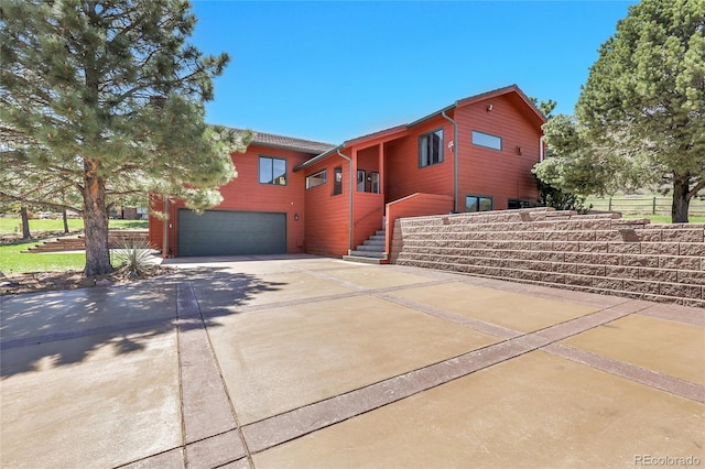 exterior space with driveway, fence, and a garage