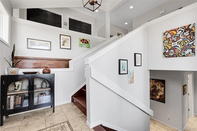staircase featuring an inviting chandelier, baseboards, and recessed lighting