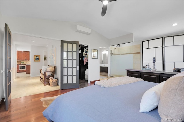 bedroom featuring lofted ceiling, french doors, recessed lighting, light wood finished floors, and connected bathroom