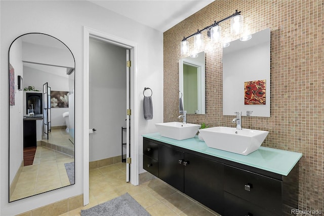 bathroom with tile patterned floors, double vanity, tile walls, and a sink