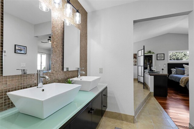 ensuite bathroom featuring plenty of natural light, tile patterned flooring, and a sink