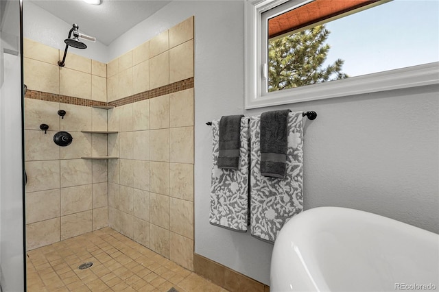full bathroom with tiled shower and a freestanding tub
