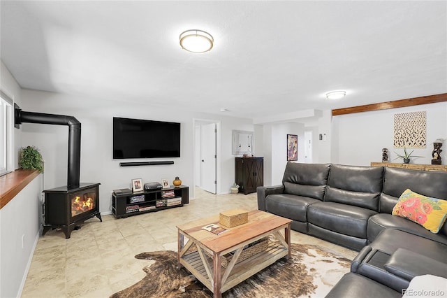 living room featuring baseboards and a wood stove