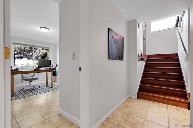 stairway featuring a wealth of natural light and baseboards