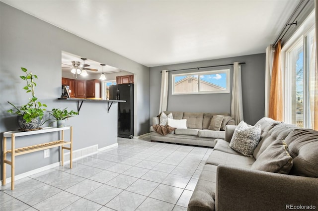 living room with ceiling fan and light tile patterned flooring