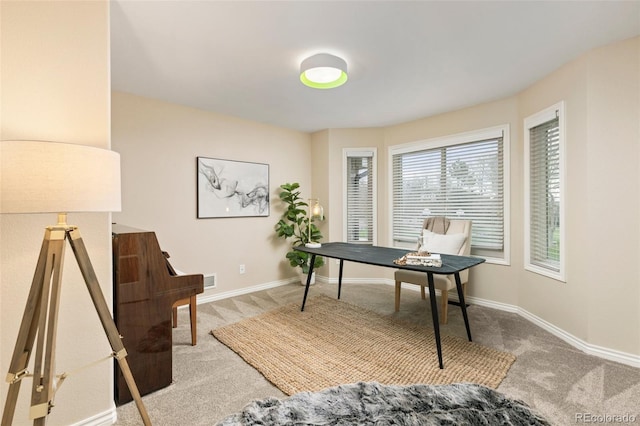 home office with baseboards and light carpet