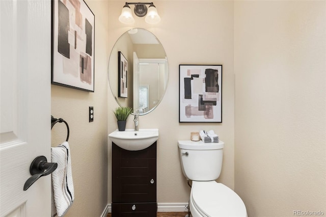 half bathroom with toilet and vanity
