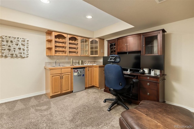 home office featuring a sink, baseboards, light carpet, and wet bar