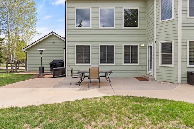 back of property with a lawn, a patio area, and fence