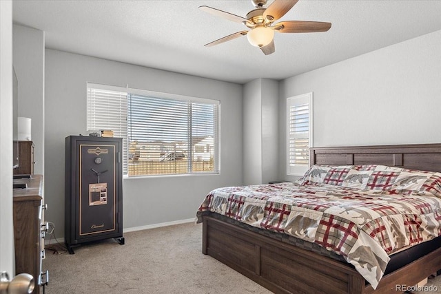 bedroom featuring ceiling fan, a textured ceiling, baseboards, and carpet flooring