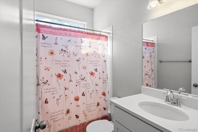 full bath featuring shower / bath combination with curtain, a textured wall, vanity, and toilet