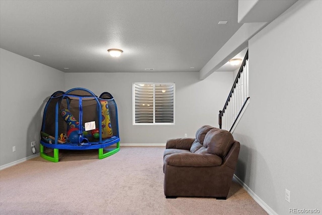 game room with carpet, baseboards, and a textured ceiling