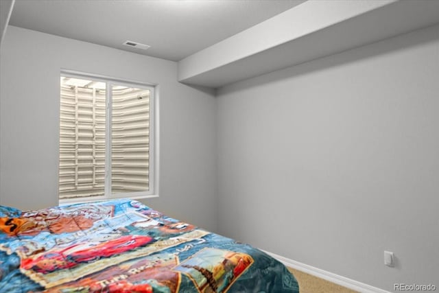 carpeted bedroom with visible vents and baseboards