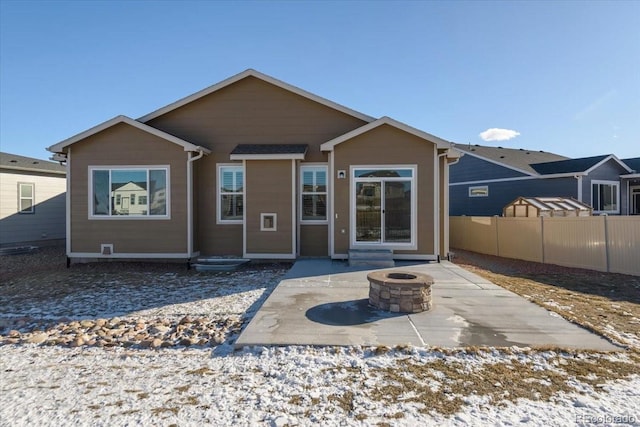 rear view of property with entry steps, a patio area, fence, and a fire pit