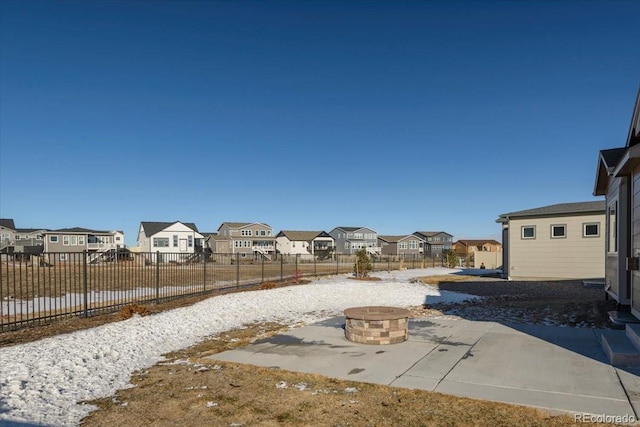 view of yard featuring a fire pit, a patio area, a fenced backyard, and a residential view