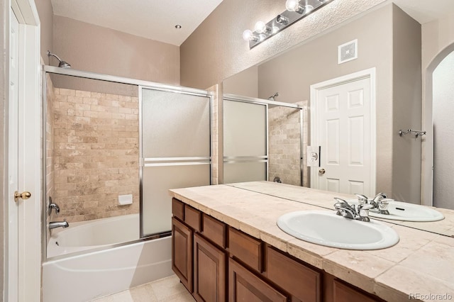 bathroom featuring vanity, tile patterned floors, and enclosed tub / shower combo