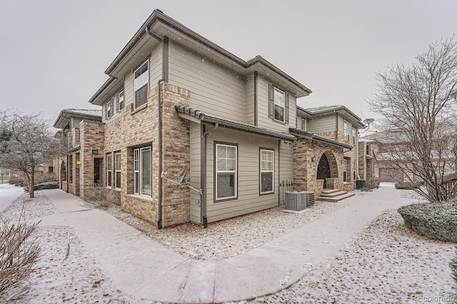 view of snowy exterior featuring central AC