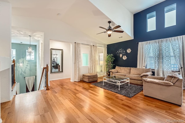 living room featuring hardwood / wood-style flooring, ceiling fan with notable chandelier, and high vaulted ceiling