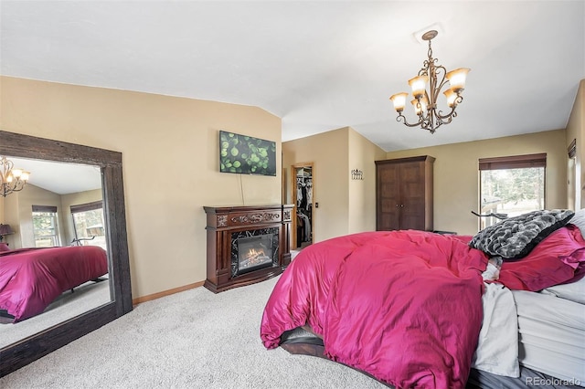 carpeted bedroom featuring multiple windows, a chandelier, and vaulted ceiling