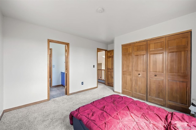 bedroom with light carpet, a closet, and ensuite bathroom