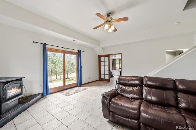 living room featuring a wood stove and ceiling fan