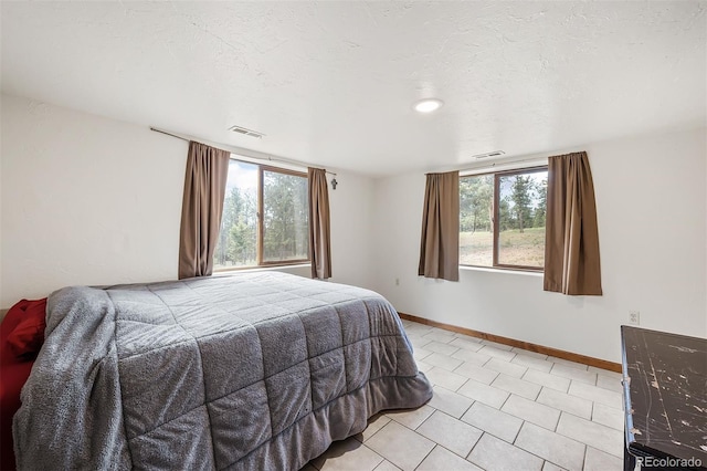 bedroom featuring multiple windows and a textured ceiling