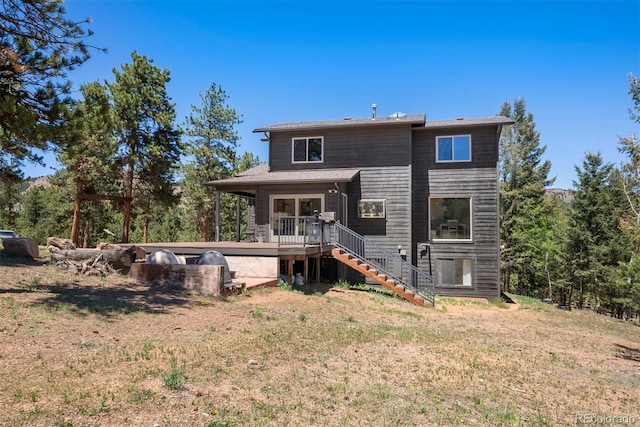 back of property with a lawn and a wooden deck