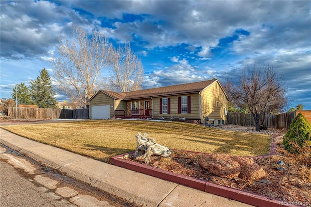 ranch-style home featuring an attached garage, fence, and a front yard