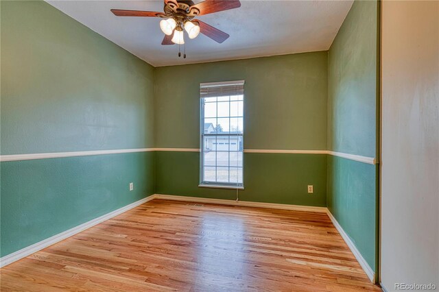 empty room with ceiling fan, baseboards, and wood finished floors