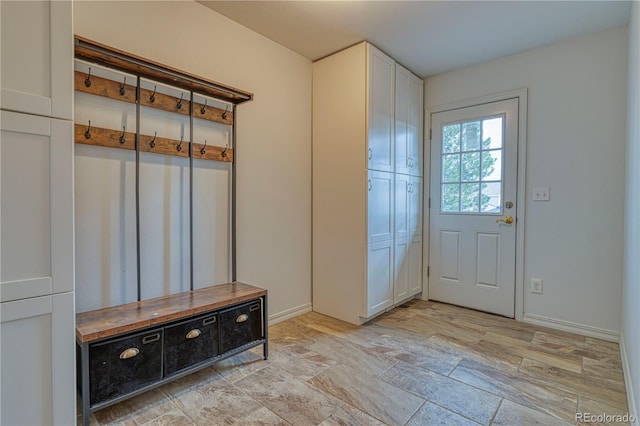 mudroom with stone finish floor and baseboards