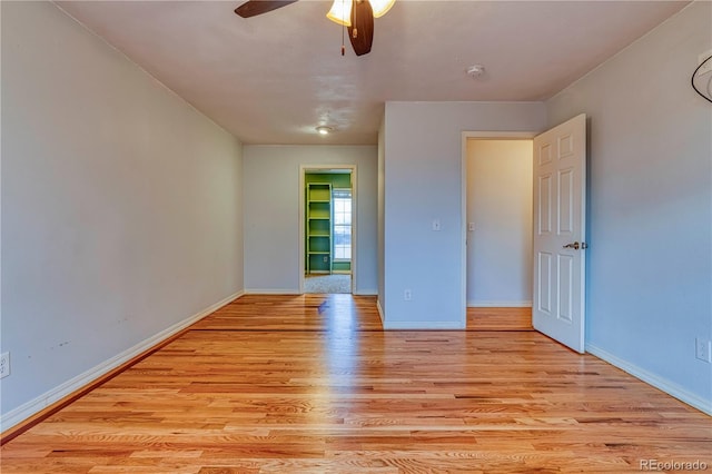 unfurnished bedroom featuring light wood-style floors, ceiling fan, and baseboards