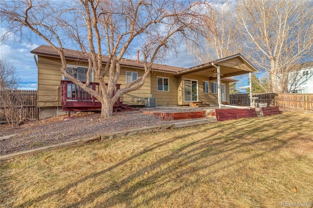 back of property featuring a ceiling fan, cooling unit, fence, and a lawn