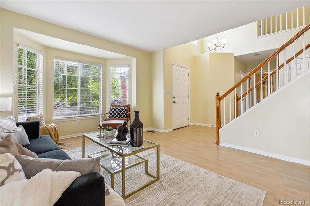 15597 E Dorado Ave, Centennial, CO 80015 - living room with wood finished floors, stairway, baseboards, and a chandelier