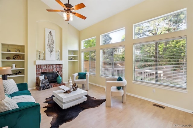 15597 E Dorado Ave, Centennial, CO 80015 - living area with high vaulted ceiling, a fireplace, wood finished floors, a ceiling fan, and baseboards
