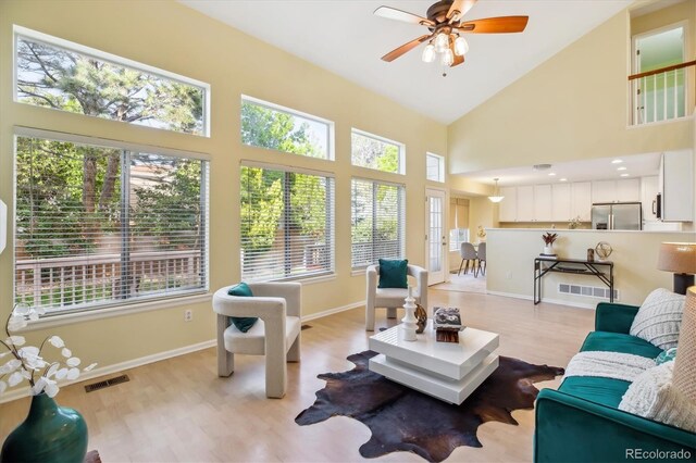 15597 E Dorado Ave, Centennial, CO 80015 - living area featuring healthy amount of natural light, light wood-style floors, ceiling fan, and high vaulted ceiling
