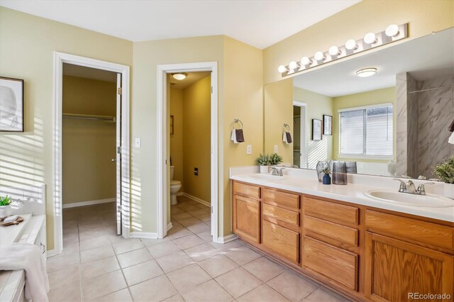 15597 E Dorado Ave, Centennial, CO 80015 - bathroom featuring double vanity, toilet, tile patterned floors, and a spacious closet