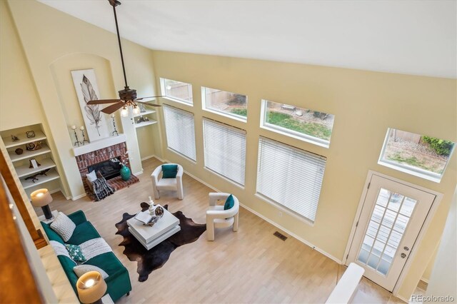 15597 E Dorado Ave, Centennial, CO 80015 - living area with high vaulted ceiling, wood finished floors, a fireplace, ceiling fan, and baseboards