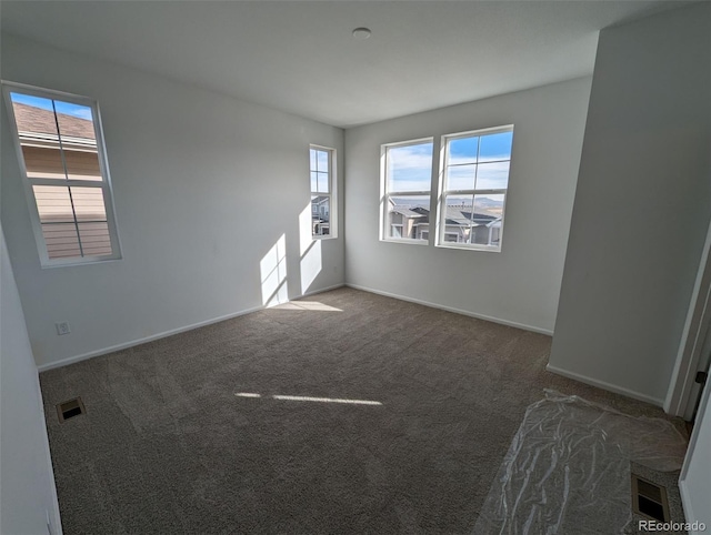 spare room featuring dark carpet