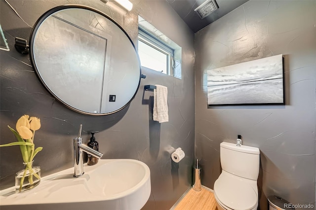 3850 Vallejo St, Denver, CO 80211 - half bath featuring a sink, wood finished floors, and toilet