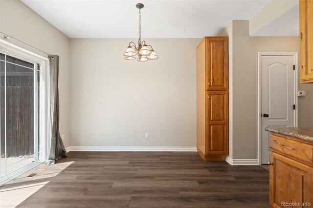 1510 York Rd Unit 100, Colorado Springs, CO 80918 - unfurnished dining area with a chandelier, dark wood-type flooring, and baseboards