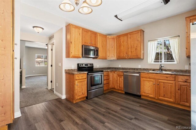 1510 York Rd Unit 100, Colorado Springs, CO 80918 - kitchen featuring stainless steel appliances, dark wood-type flooring, a sink, baseboards, and a chandelier