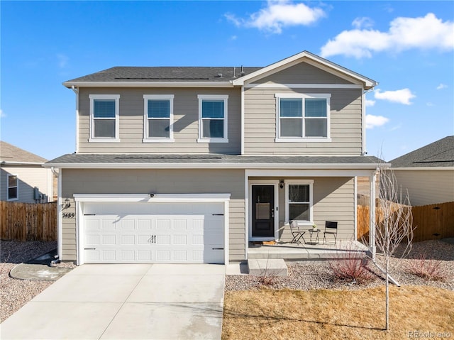 traditional home featuring concrete driveway, a porch, an attached garage, and fence