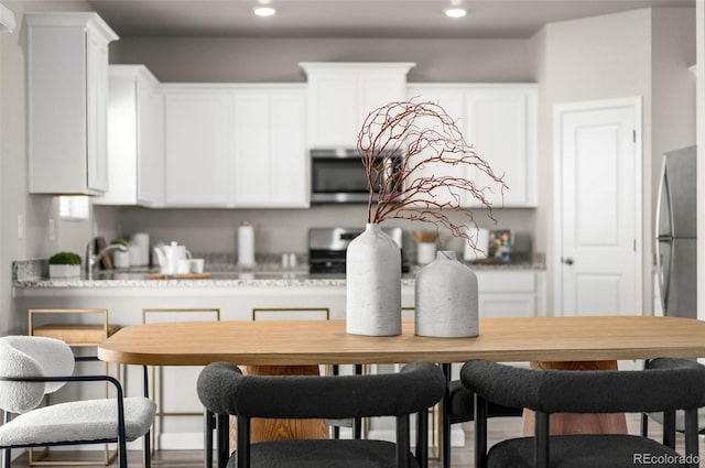 kitchen with appliances with stainless steel finishes, recessed lighting, and white cabinets