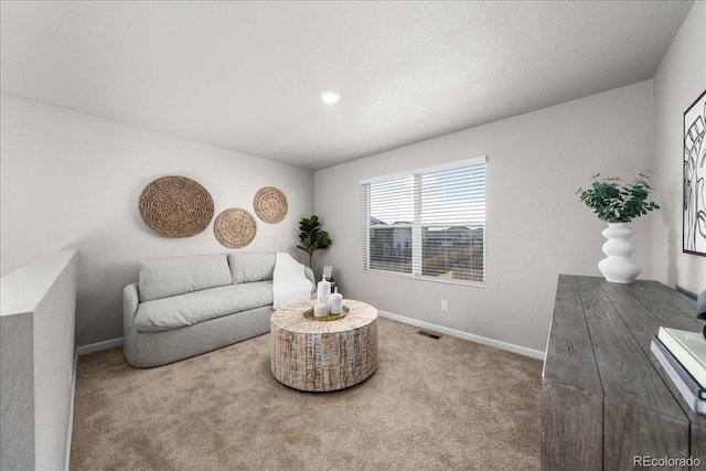 sitting room with carpet flooring, visible vents, and baseboards