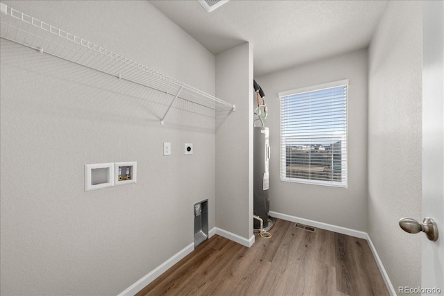 clothes washing area featuring laundry area, washer hookup, wood finished floors, baseboards, and electric dryer hookup