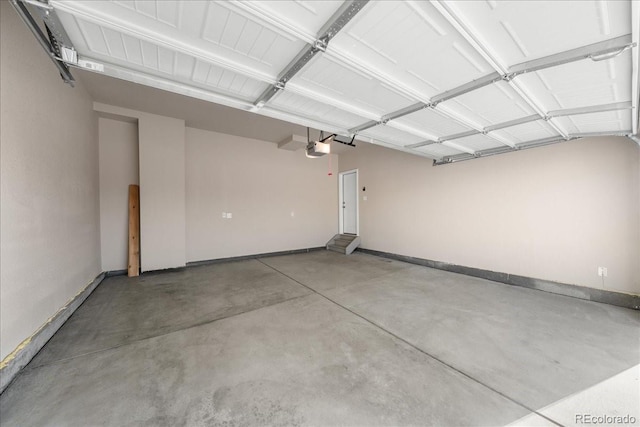 garage featuring a garage door opener and baseboards